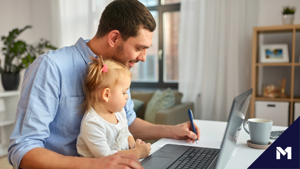 Man working from home with infant daughter on his lap.