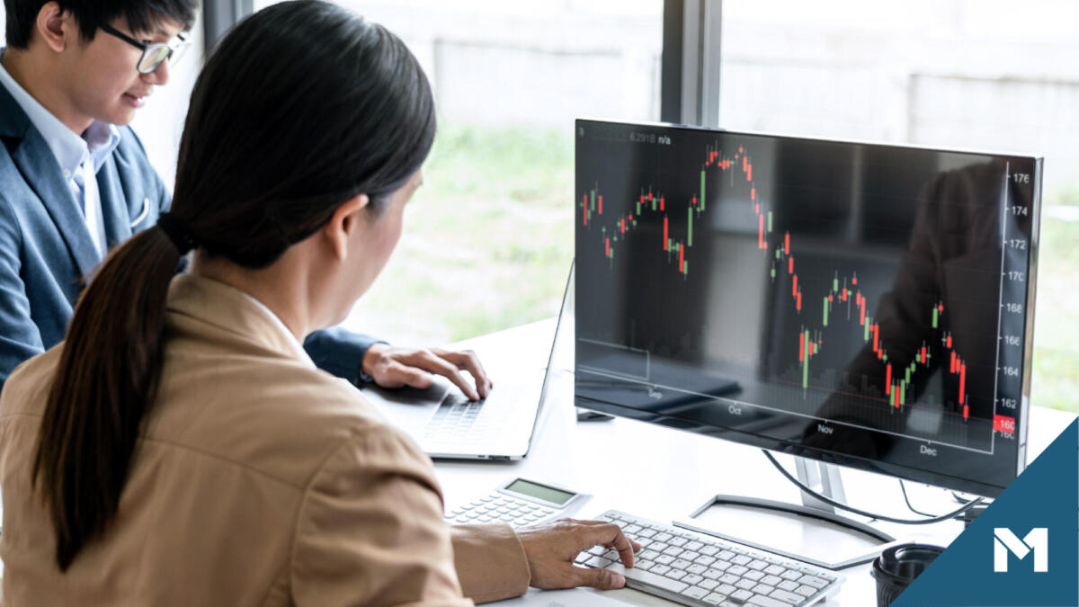 Man and woman looking at quarterly market performance on a computer screen