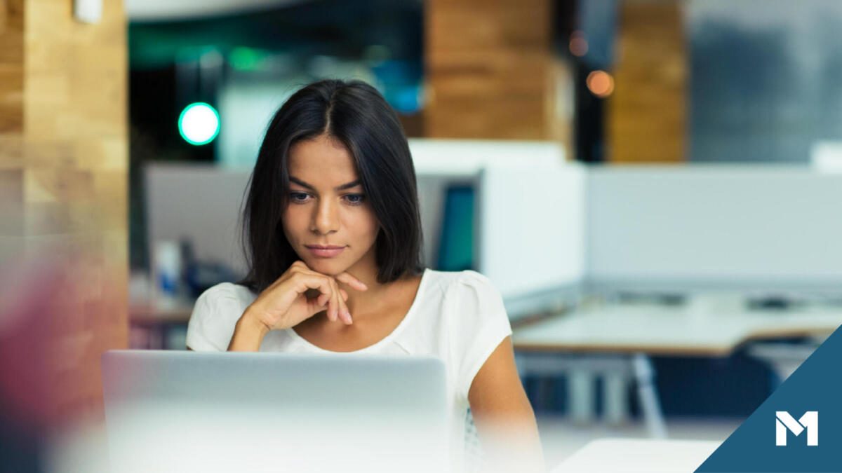 Young woman in office looking at laptop