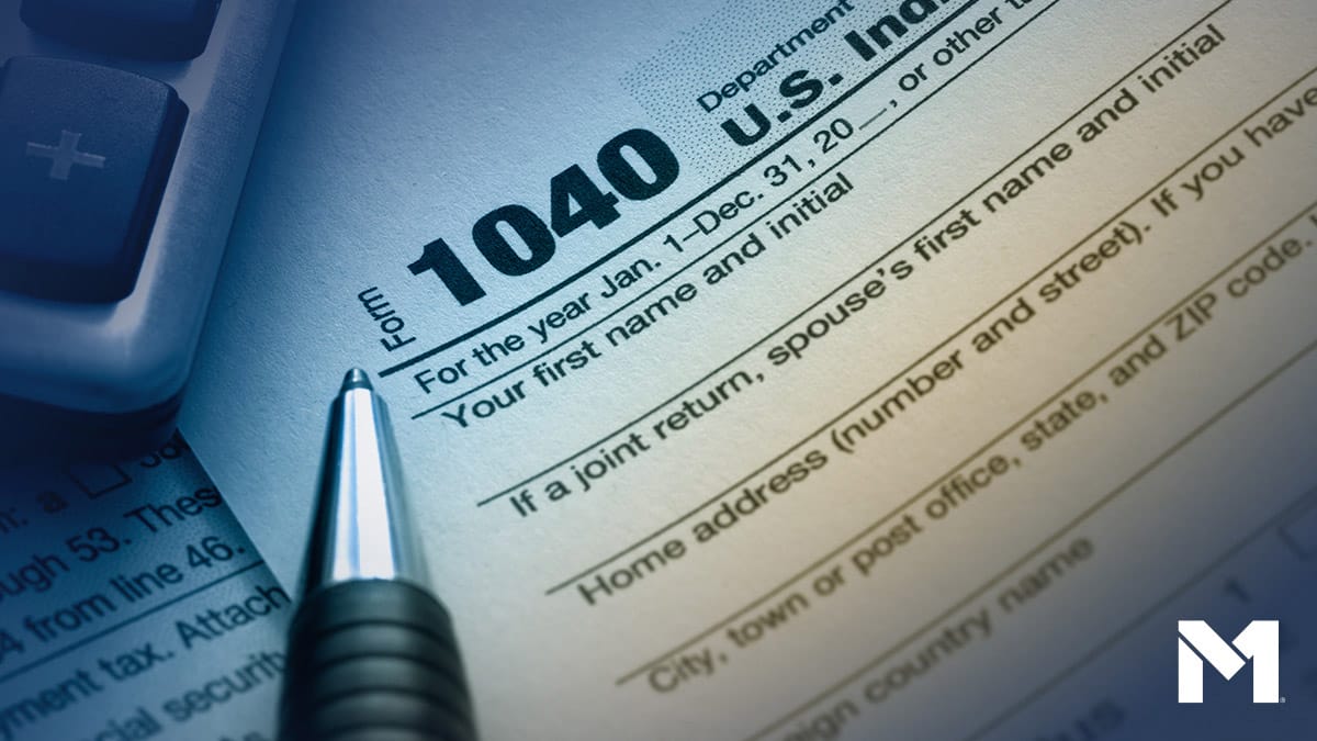 Closeup of IRS form 1040 and a pen, with part of a calculator visible.