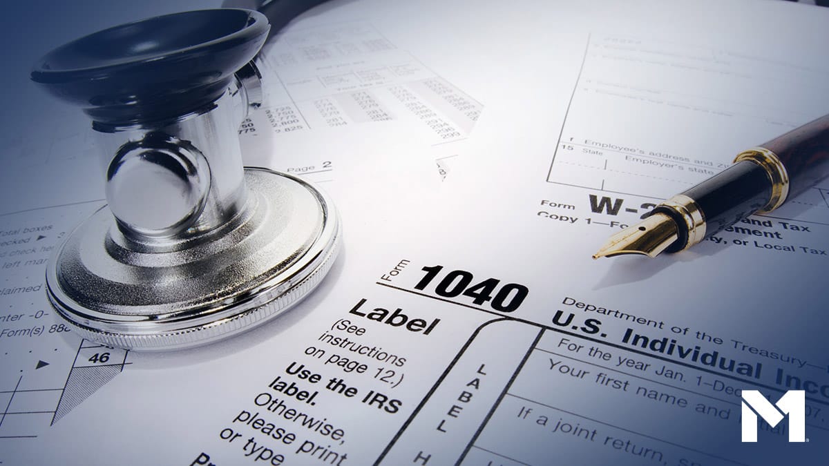Closeup of IRS tax form 1040 surrounded by various writing implements.